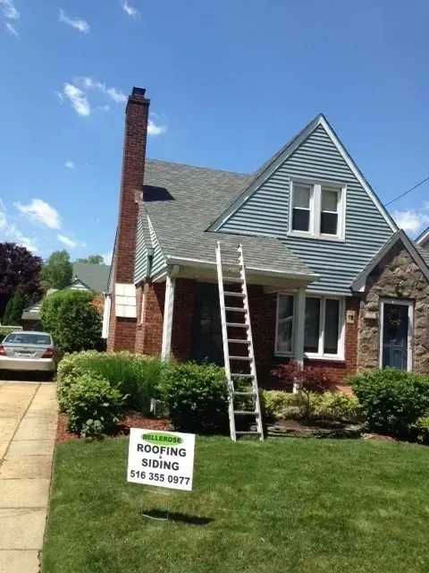 Blue-gray home during a roofing and siding project